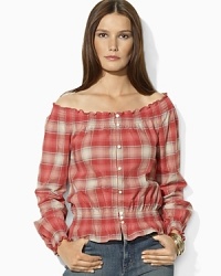 A soft woven cotton top channels western inspiration with a faded plaid pattern and smocked detailing. A soft woven cotton top channels western inspiration with a faded plaid pattern and smocked detailing.