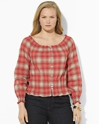 A soft woven cotton top channels western inspiration with a faded plaid pattern and smocked detailing.