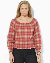 A soft woven cotton top channels western inspiration with a faded plaid pattern and smocked detailing.