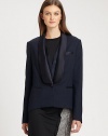 A modern variation on the traditional tuxedo, with feminine touches including an extended satin collar