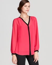 Approach color blocking with sophisticated restraint in this DKNYC blouse featuring clean lines and contrast trim for a thoroughly modern look. Approach color blocking with sophisticated restraint in this DKNYC blouse featuring clean lines and contrast trim for a thoroughly modern look.