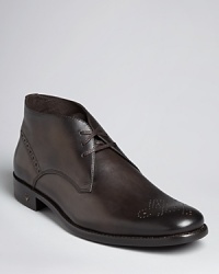 This stellar design from John Varvatos USA is defined by its classic Chukka boot shape and the decorative perforated detail upon the smooth toe box and counter, a handsome dress boot that meets every occasion with rugged distinction. This stellar design from John Varvatos USA is defined by its classic Chukka boot shape and the decorative perforated detail upon the smooth toe box and counter, a handsome dress boot that meets every occasion with rugged distinction.