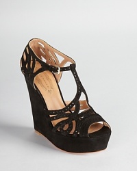 Pops of patent leather peek out from perforated details on Elie Tahari's Wendy wedges, a strappy style in jet black suede. Pops of patent leather peek out from perforated details on Elie Tahari's Wendy wedges, a strappy style in jet black suede.