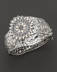 A bold cuff in sterling silver with mother of pearl and blue topaz accents. A bold cuff in sterling silver with mother of pearl and blue topaz accents.