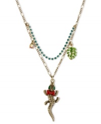Reptilian fashion from Betsey Johnson. This pendant necklace features a gold tone chain with a blue-colored crystal cup chain. The alligator pendant features green-colored crystal eyes, pink bows, green leaf charm and small crystal accent. Crafted in antiqued gold tone mixed metal. Approximate length: 16 inches + 3-inch extender. Approximate drop: 2 inches. Reptilian fashion from Betsey Johnson. This pendant necklace features a gold tone chain with a blue-colored crystal cup chain. The alligator pendant features green-colored crystal eyes, pink bows, green leaf charm and small crystal accent. Crafted in antiqued gold tone mixed metal. Approximate length: 16 inches + 3-inch extender. Approximate drop: 2 inches.