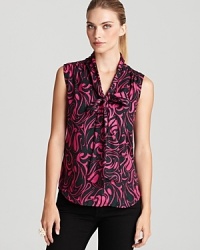 Spun from silk with a contrast swirled print, this pretty Trina Turk blouse is an ideal layering piece but stands on its own--wear it now, add a blazer come fall. Spun from silk with a contrast swirled print, this pretty Trina Turk blouse is an ideal layering piece but stands on its own--wear it now, add a blazer come fall.