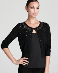 A constellation of beading beams from the neckline of a cropped DKNY cardigan for a chic statement. A constellation of beading beams from the neckline of a cropped DKNY cardigan for a chic statement.