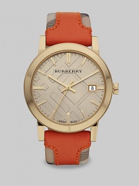 An iconic haymarket check strap with a pop of brilliant color in supple leather on a goldtone case. Quartz movementWater resistant to 5 ATMRound goldtone stainless steel case, 38mm (1.5)Smooth bezelLight trench check stamped dialBar hour markersDate display at 3 o'clockSecond hand Orange leather accented haymarket check strapMade in Switzerland An iconic haymarket check strap with a pop of brilliant color in supple leather on a goldtone case. Quartz movementWater resistant to 5 ATMRound goldtone stainless steel case, 38mm (1.5)Smooth bezelLight trench check stamped dialBar hour markersDate display at 3 o'clockSecond hand Orange leather accented haymarket check strapMade in Switzerland