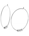 Michael Kors adds an elegant touch to its pair of hoop earrings. Crafted from silver ion-plated mixed metal, the earrings feature glass pave fireballs for a lustrous touch. Approximate diameter: 2 inches.