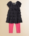 This charming two piece set for your little girl pairs a ruffled, denim tunic and boldly hued leggings with snap hem. Tunic ScoopneckShort sleeves with ruffled cuffsBack keyhole buttonRuffled hem Pants Elastic waistbandSnap hemTunic: 66% cotton/28% polyester/6% spandexLeggings: 57% cotton/38% polyester/5% spandexMachine washImported