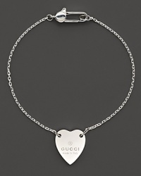 From the Trademark Collection, this sweet sterling silver bracelet features a woven chain with engraved logo heart charm. Designed by Gucci.