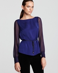 A searing jewel tone glows atop a fluid T Tahari blouse, finished with sheer sleeves and a high/low hem for contemporary edge. Slip the statement silhouette over dark denim for modern polish. A searing jewel tone glows atop a fluid T Tahari blouse, finished with sheer sleeves and a high/low hem for contemporary edge. Slip the statement silhouette over dark denim for modern polish.