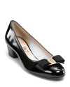 Sophisticated patent leather pumps with a classic Ferragamo bow and logo plate at toe.