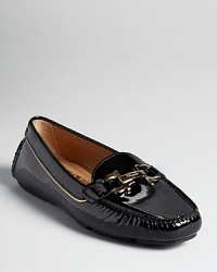 Patent leather and a golden logo accent make a streamlined Salvatore Ferragamo loafer shine. Patent leather and a golden logo accent make a streamlined Salvatore Ferragamo loafer shine.
