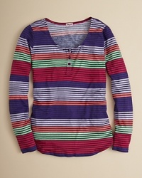 This henley-style tunic bursts onto the scene with sunny ministripes in alternating bands and a flowing, lightweight drape. This henley-style tunic bursts onto the scene with sunny ministripes in alternating bands and a flowing, lightweight drape.