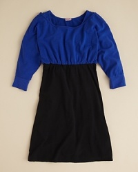 An empire waist dress is pulled together with stark contrast colorblocks and ruched trim. An empire waist dress is pulled together with stark contrast colorblocks and ruched trim.