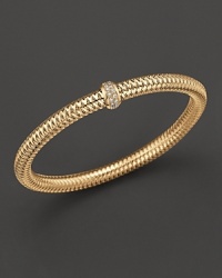 A row of diamonds binds this woven 18K yellow gold bracelet from Roberto Coin. A row of diamonds binds this woven 18K yellow gold bracelet from Roberto Coin.