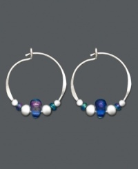 Petite hoops with a lot of character. These sterling silver hoops by Jody Coyote feature silver accents beads and light blue Czech glass beads. Approximate size: 5/8 inch x 3/4 inch.