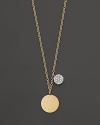 This gold medallion necklace is paired with a mini diamond pavé medallion. Designed by Meira T.