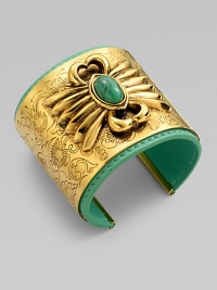 A striking relief design with a colorful turquoise stone is the centerpiece of a wide, delicately etched golden cuff layered over a bright leather interior.TurquoiseLeatherGoldplatedDiameter, about 2¼Width, about 2Made in France A striking relief design with a colorful turquoise stone is the centerpiece of a wide, delicately etched golden cuff layered over a bright leather interior.TurquoiseLeatherGoldplatedDiameter, about 2¼Width, about 2Made in France