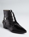 Polished leather, a streamlined silhouette and a wrap-around buckle update the basic bootie, by CoSTUME NATIONAL.