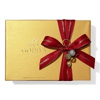 A classic assortment of Belgian chocolates from Godiva comes in a beautiful gold box tied with big red bow and holiday pick. Each ballotin includes Godiva signature favorite ganaches, pralines, caramels, fruits and nuts in milk, dark and white chocolate.