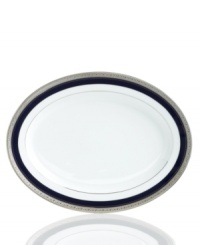 Formal white fine china displays a dramatic combination of scrolling leaves on shimmering platinum and an inner band of intense cobalt blue. Dishwasher safe. Formal white fine china displays a dramatic combination of scrolling leaves on shimmering platinum and an inner band of intense cobalt blue. Dishwasher safe.