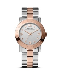 Two tone metals are this season's trend story, and this MARC BY MARC JACOBS analog watch stylizes the look with a logo-etched top ring and classic bracelet. Two tone metals are this season's trend story, and this MARC BY MARC JACOBS analog watch stylizes the look with a logo-etched top ring and classic bracelet.