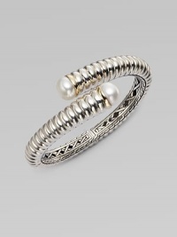 From the Bedeg Collection. A richly ribbed hinged cuff of gleaming sterling silver with accents of 18k gold has overlapping endcaps set with lustrous pearls.White pearlsSterling silver and 18k yellow goldDiameter, about 2¼Width, about ½HingedImported From the Bedeg Collection. A richly ribbed hinged cuff of gleaming sterling silver with accents of 18k gold has overlapping endcaps set with lustrous pearls.White pearlsSterling silver and 18k yellow goldDiameter, about 2¼Width, about ½HingedImported