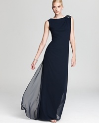 Sleek and statuesque, this Tadashi Shoji gown boasts glamour and sophistication. An embellished shoulder, sheer overlay and back slit lend special details. Sleek and statuesque, this Tadashi Shoji gown boasts glamour and sophistication. An embellished shoulder, sheer overlay and back slit lend special details.