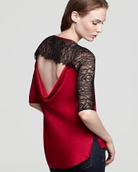 A glamorous top with a striking black and red contrast, lace details and a surprise opening in back for an unforgettable exit. A glamorous top with a striking black and red contrast, lace details and a surprise opening in back for an unforgettable exit.