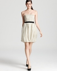 Origami-like pleats at the skirt lend dimension to this frothy Vera Wang Lavender Label strapless dress, finished with a contrasting ribbon belt for polish. Origami-like pleats at the skirt lend dimension to this frothy Vera Wang Lavender Label strapless dress, finished with a contrasting ribbon belt for polish.