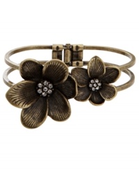 Vintage inspiration. Two flowers with sparkling crystal centers create an earthy illusion on Fossil's pretty bangle bracelet. Set in brass tone mixed metal with a hinge clasp. Approximate diameter: 2-1/2 inches.