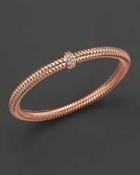 A row of diamonds binds this woven 18K rose gold bracelet from Roberto Coin. A row of diamonds binds this woven 18K rose gold bracelet from Roberto Coin.