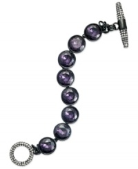 Purple reigns. This toggle bracelet from Juicy Couture showcases round glass stones in purple hues. Finished with a toggle closure embellished with pave accents. Crafted in silver tone mixed metal. Approximate length: 7-1/2 inches.