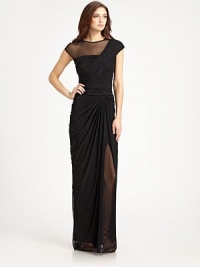 This elegant gown is rendered in fluid drape jersey and accented with a sheer illusion neckline panel.Jewel necklineCap sleevesIllusion asymmetrical necklineRuched bodiceDraped skirtConcealed back zipFully linedAbout 53 from natural waist93% nylon/7% spandexDry cleanImportedModel shown is 5'11 (180cm) wearing US size Small.OUR FIT MODEL RECOMMENDS ordering true size. This elegant gown is rendered in fluid drape jersey and accented with a sheer illusion neckline panel.Jewel necklineCap sleevesIllusion asymmetrical necklineRuched bodiceDraped skirtConcealed back zipFully linedAbout 53 from natural waist93% nylon/7% spandexDry cleanImportedModel shown is 5'11 (180cm) wearing US size Small.OUR FIT MODEL RECOMMENDS ordering true size.