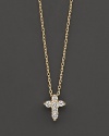 A diamond cross necklace in yellow gold. With signature ruby accent. Designed by Roberto Coin.