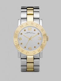 A sleek timepiece with a logo etched bezel and dazzling crystal markers. Quartz movementWater resistant to 5 ATMRound stainless steel case, 36mm (1.4) Logo etched goldtone ion-plated bezelSilver dialCrystal and numeric hour markersSecond hand Two-tone stainless steel link braceletImported A sleek timepiece with a logo etched bezel and dazzling crystal markers. Quartz movementWater resistant to 5 ATMRound stainless steel case, 36mm (1.4) Logo etched goldtone ion-plated bezelSilver dialCrystal and numeric hour markersSecond hand Two-tone stainless steel link braceletImported