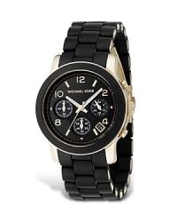 The must-have sport watch of the season. From MICHAEL Michael Kors, the chronograph in black rubber with a stainless steel and goldplated case. Black glossy dial with shiny gold numbers and stick indices. The must-have sport watch of the season. From MICHAEL Michael Kors, the chronograph in black rubber with a stainless steel and goldplated case. Black glossy dial with shiny gold numbers and stick indices.