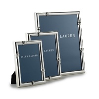 Smooth, shining silver-plated brass is decorated with a simple embossed design at each corner in this effortlessly elegant frame from Ralph Lauren Home. Smooth, shining silver-plated brass is decorated with a simple embossed design at each corner in this effortlessly elegant frame from Ralph Lauren Home.