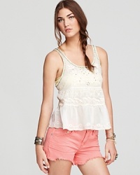 Beading and neon embroidery embellish an ivory cotton Free People tank flaunting a playful peplum--the whimsical addition to your summer wardrobe the balmy season is wanting for.