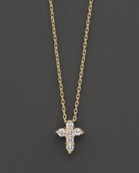 A diamond cross necklace in yellow gold. With signature ruby accent. Designed by Roberto Coin.