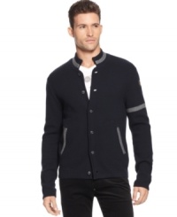 A button-front cardigan that quotes the collegiate with armband and color-tipped handwarmer pockets, from Armani Jeans. A button-front cardigan that quotes the collegiate with armband and color-tipped handwarmer pockets, from Armani Jeans.