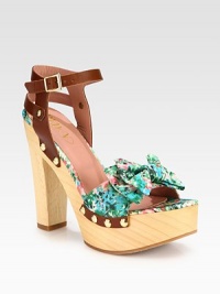 A dimensional bow tops this clog-inspired design with a powerful wooden heel and platform. Wooden heel, 5¼ (130mm)Wooden platform, 1¾ (45mm)Compares to a 3½ heel (90mm)Nylon and leather upper with metal studsAdjustable ankle strapLeather liningRubber solePadded insoleMade in Italy A dimensional bow tops this clog-inspired design with a powerful wooden heel and platform. Wooden heel, 5¼ (130mm)Wooden platform, 1¾ (45mm)Compares to a 3½ heel (90mm)Nylon and leather upper with metal studsAdjustable ankle strapLeather liningRubber solePadded insoleMade in Italy