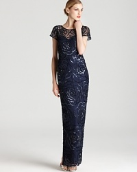 Aidan Mattox dresses up a simple sheath silhouette with a long length and sparkling, sequined floral details. Aidan Mattox dresses up a simple sheath silhouette with a long length and sparkling, sequined floral details.
