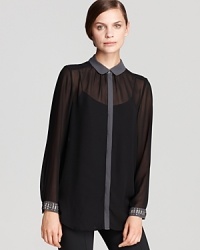 A dark palette and sheer styling infuse a demure DKNYC blouse with sophisticated drama, while studded cuffs finish the style with rocker-chic shine. A dark palette and sheer styling infuse a demure DKNYC blouse with sophisticated drama, while studded cuffs finish the style with rocker-chic shine.