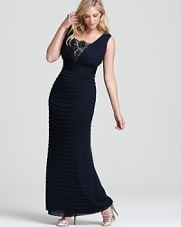 In a long, curve-skimming silhouette, Adrianna Papell's ribbed and pintucked gown showcases a delicate lace inset at the bust. In a long, curve-skimming silhouette, Adrianna Papell's ribbed and pintucked gown showcases a delicate lace inset at the bust.