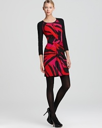 Solid raglan sleeves lend edgy contrast to a vibrantly printed DKNY dress, crafted with a modern front twist. Solid raglan sleeves lend edgy contrast to a vibrantly printed DKNY dress, crafted with a modern front twist.