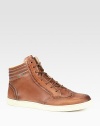 Cuir leather with web loop at ankle.Padded back ankleRubber sole embossed with Gucci scriptMade in Italy