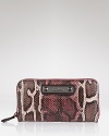 Sam Edelman's sleek snake print wallet keeps your essentials safely stowed with a secure zip around closure.